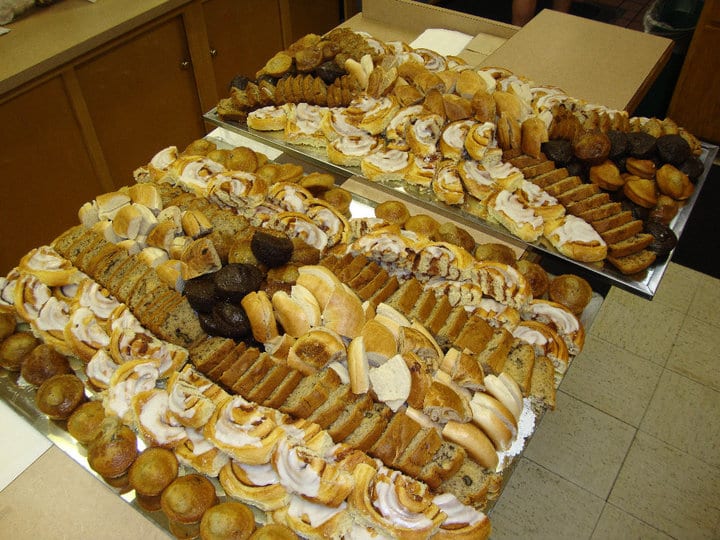A catering breakfast platter of pastries, muffins and sliced fruit.