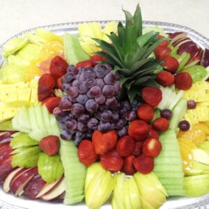 A platter of cut melon, pineapple, grapes and berries.