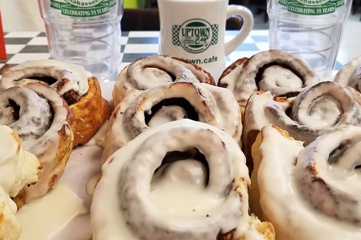 A tray of iced cinnamon rolls fresh out of the oven.